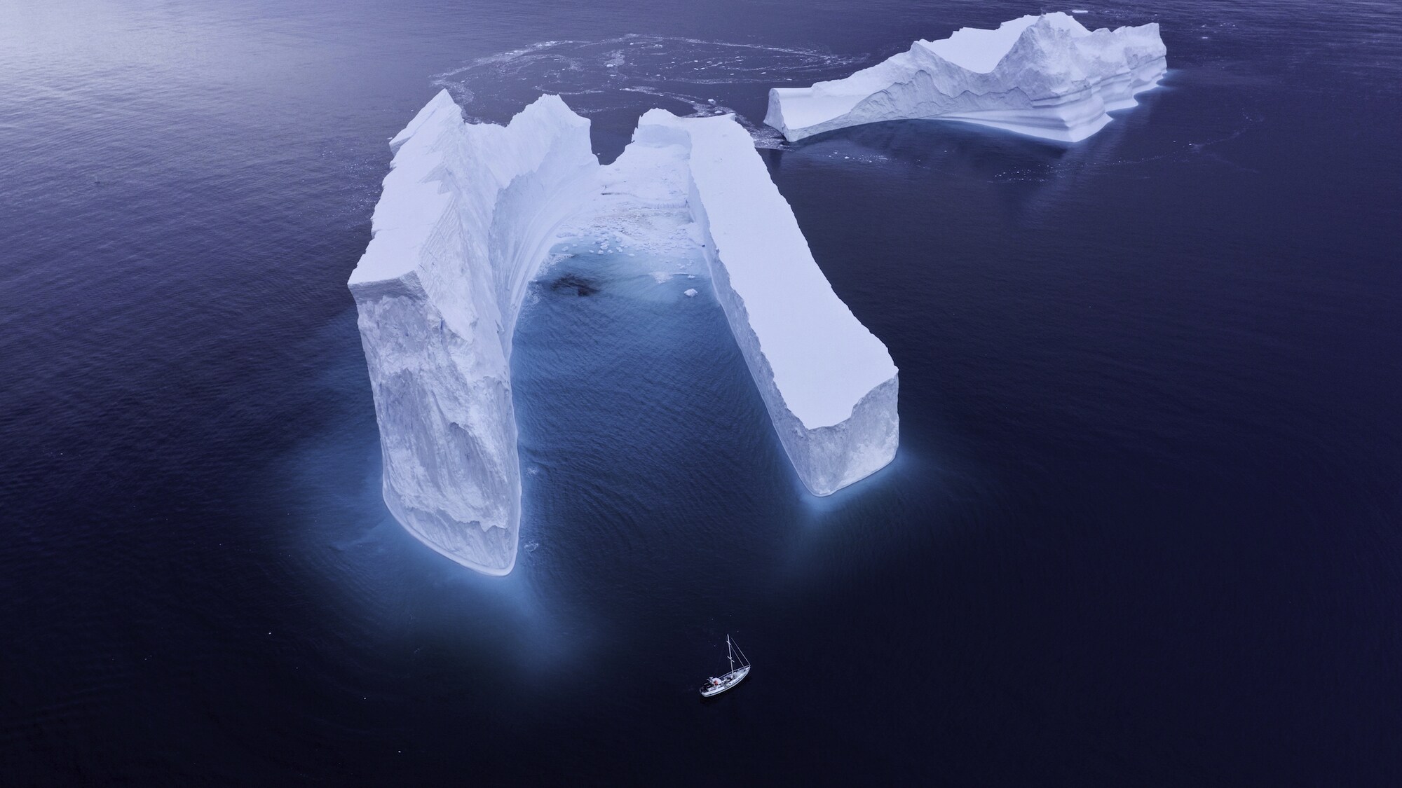 Antarctic icebergs dwarfed the team's expedition vessel, The Australis, while the team filmed humpbacks at the bottom of the world. (National Geographic for Disney+/Hayes Baxley)