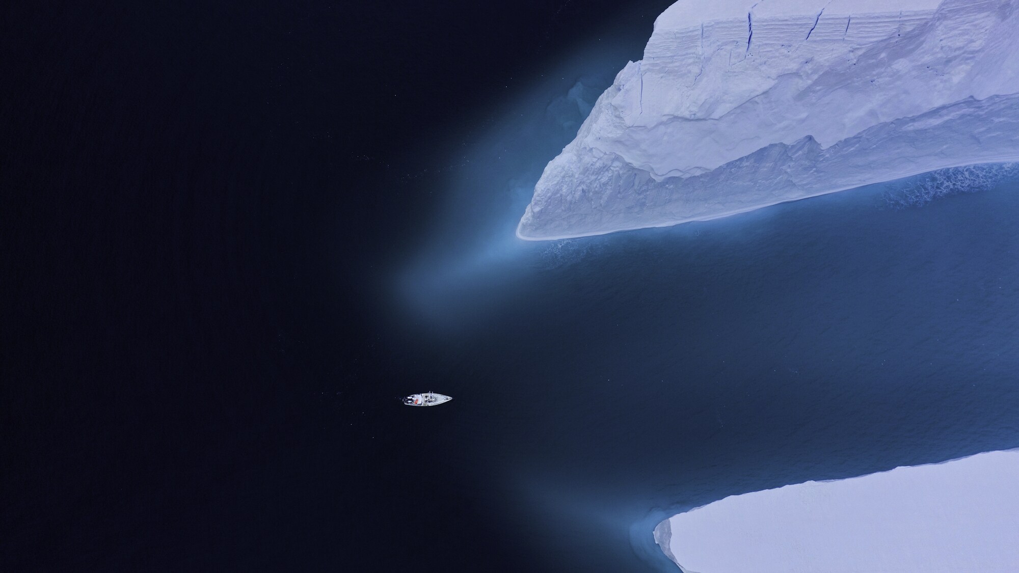 Antarctic icebergs dwarfed the team's expedition vessel, The Australis, while the team filmed humpbacks at the bottom of the world. (National Geographic for Disney+/Hayes Baxley)
