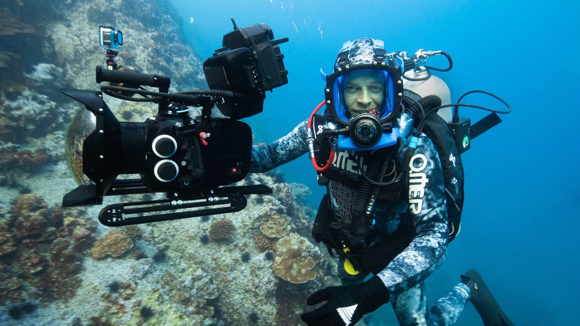 Bertie Gregory near reef with his camera. (Credit: National Geographic/Hugh Pearson for Disney+)