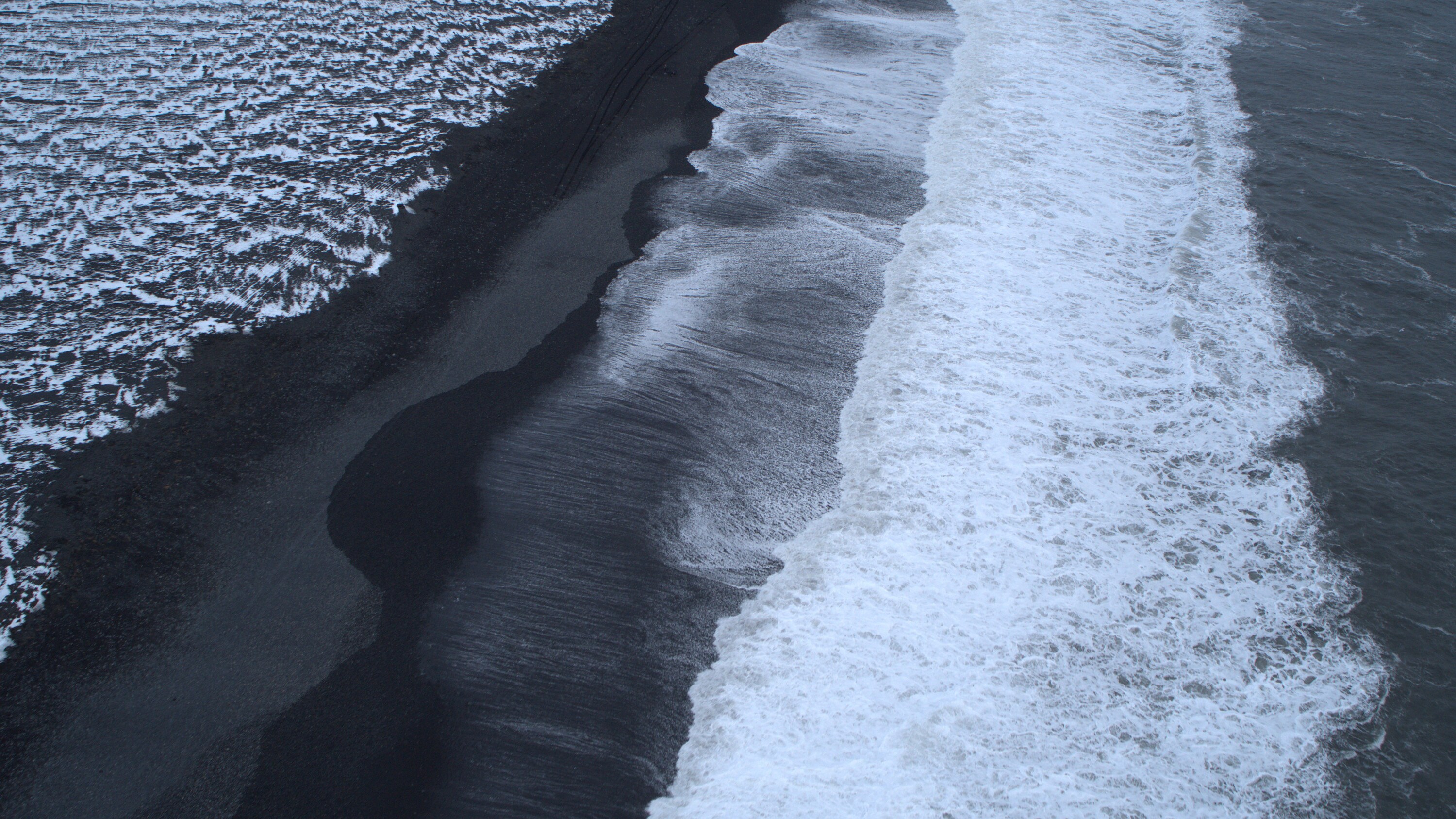 Ocean waves crash onto the black sand of Reynisfjara Beach. (National Geographic for Disney+)