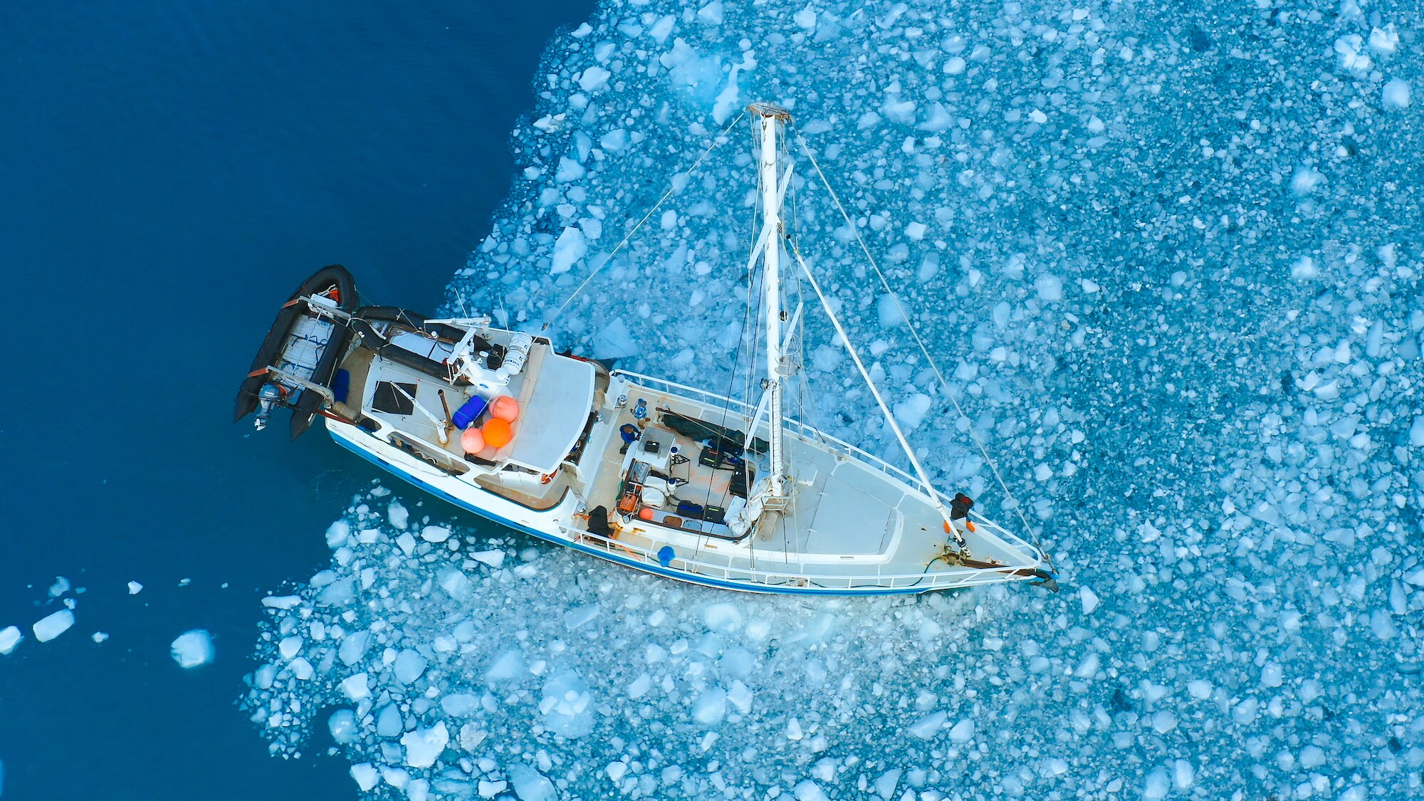 The crew's boat sailing through sheets of sea ice. (Credit: National Geographic/Bertie Gregory for Disney+)