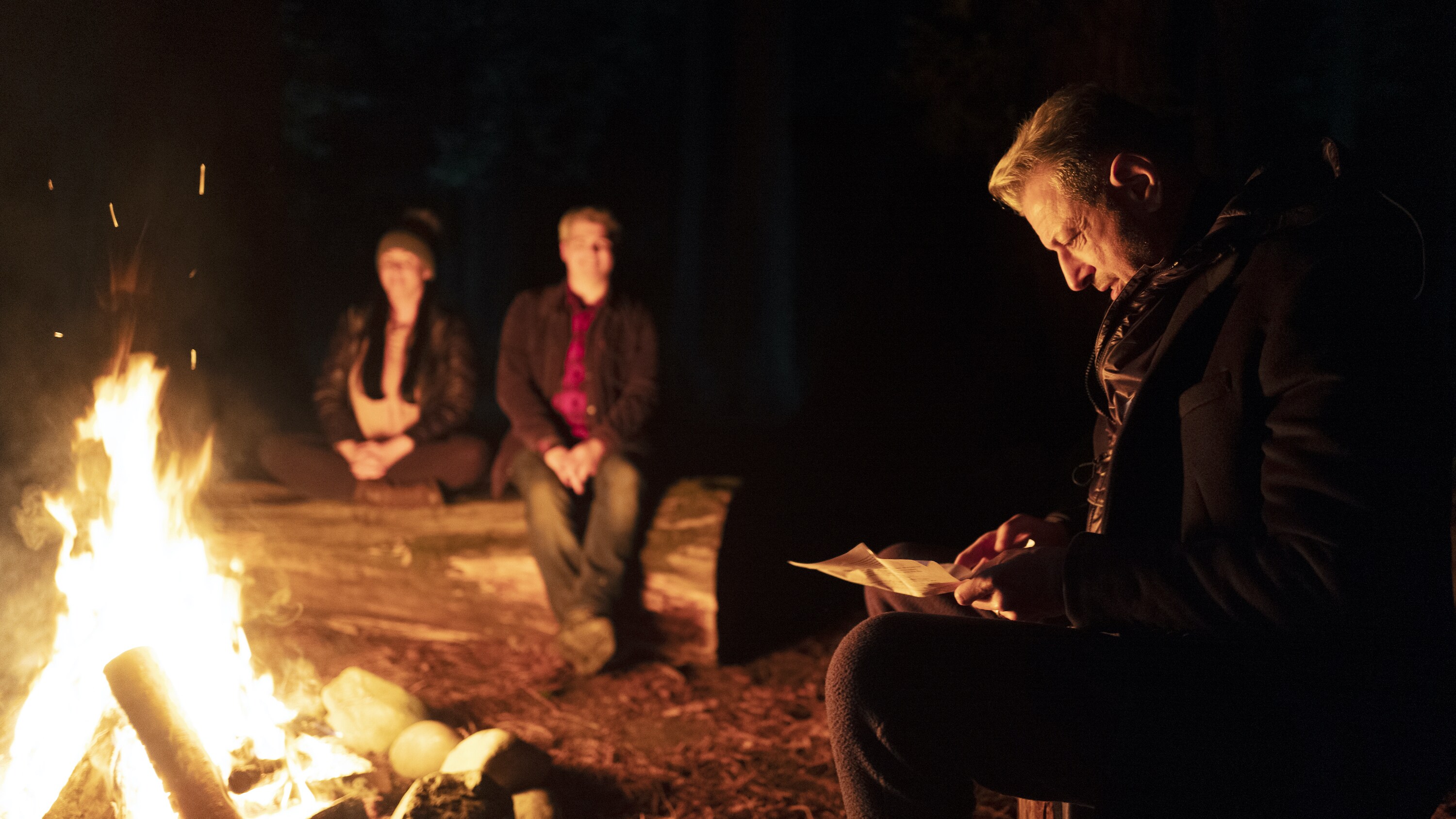 Eureka, CA - Jeff Goldblum (R) around the camp fire in Eureka Forest after hunting for Big Foot with cryptozoologists Dana Newkirk (L) and Greg Newkirk (center). (Credit: National Geographic/Seppi Aghajani)