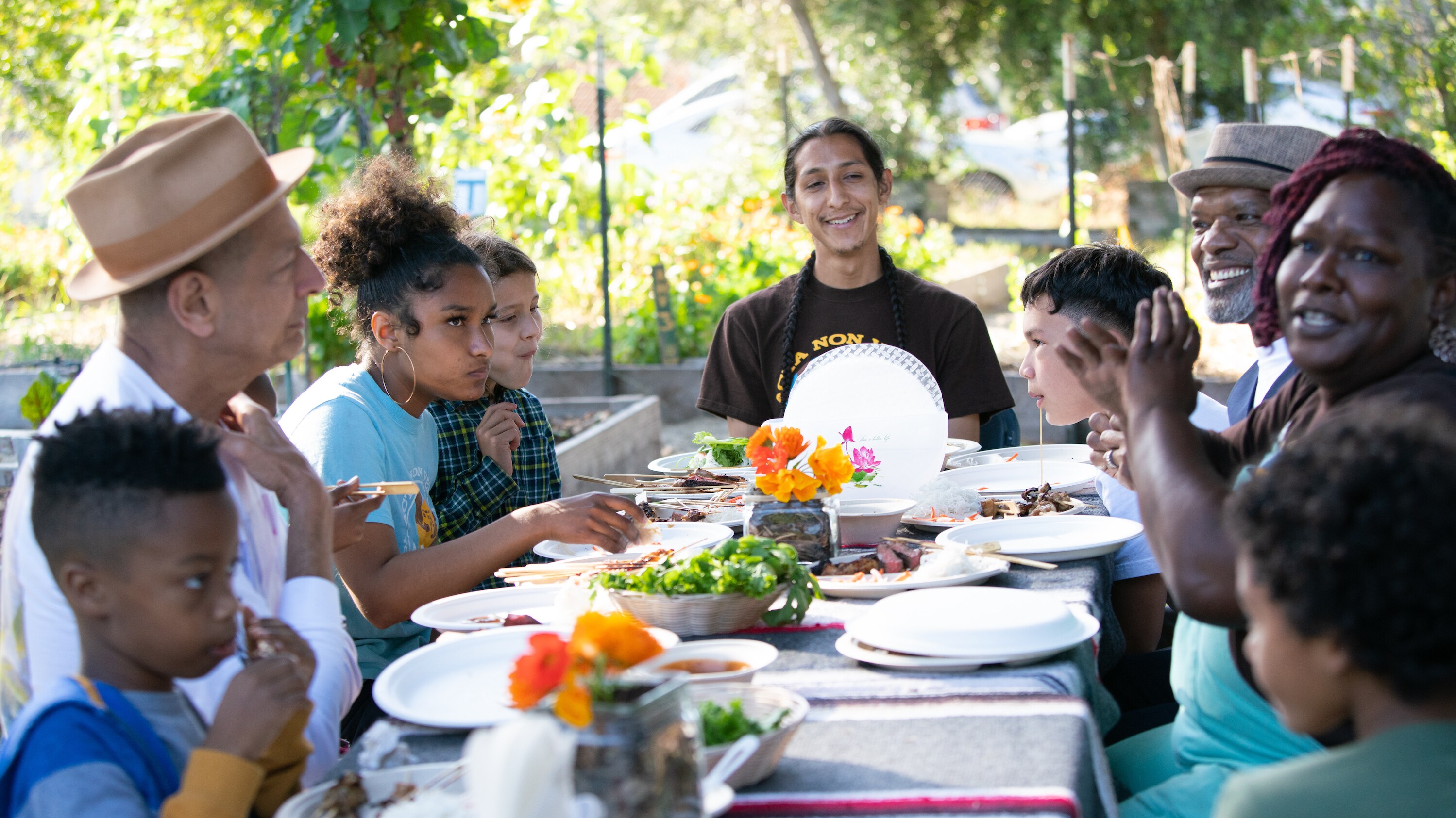 Oakland, CA - Members of the Urban Garden gathered around dining table. (Credit: National Geographic)