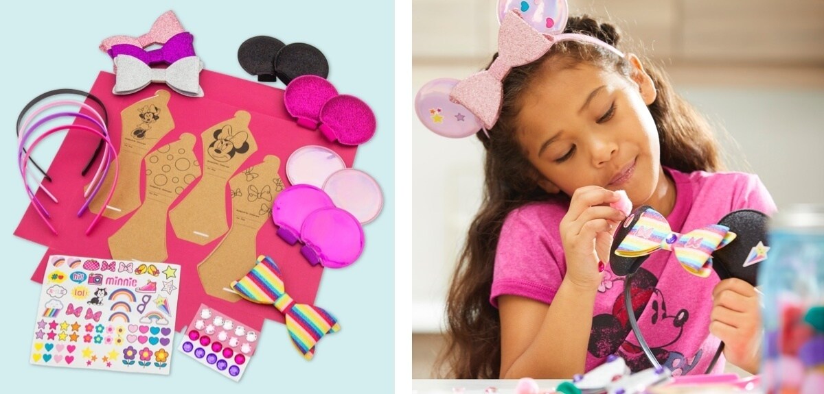 Ragazza che attacca un pompon su un paio di orecchie Minnie Mouse nere con arco arcobaleno, una selezione di orecchie imbottite, fiocchi e accessori.