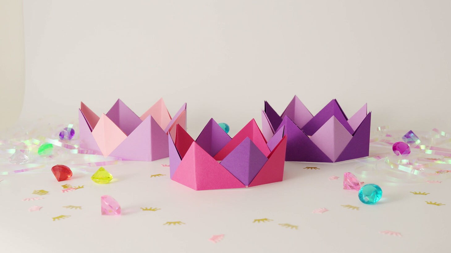 Princess party craft with colourful paper crowns and gem decorations.
