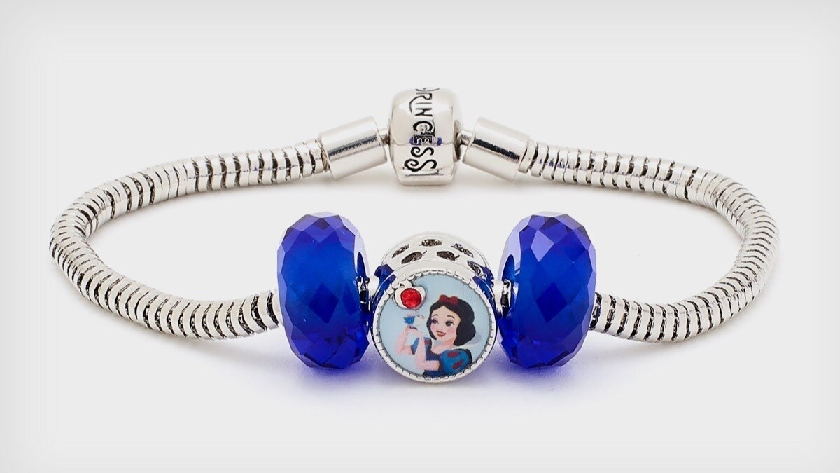 Das dreiteilige Set besteht aus einer kreisförmigen Perle mit klassischem Tiana-Charakter-Motiv und zwei blau passenden Glasperlen.