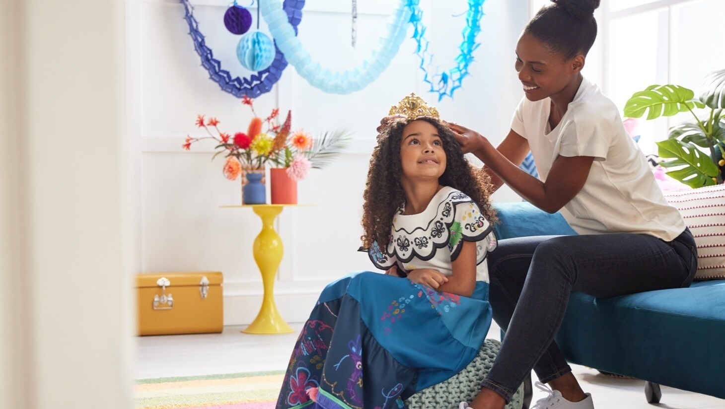A woman placing a tiara onto a little girls head