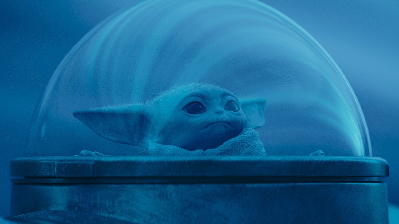 Grogu peering out of a starfighter's bubble window in the Disney+ Original series, Star Wars: The Mandalorian, Season 3.