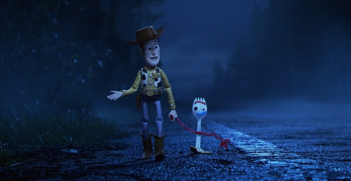 Woody and Forky holding hands whilst walking down a road.