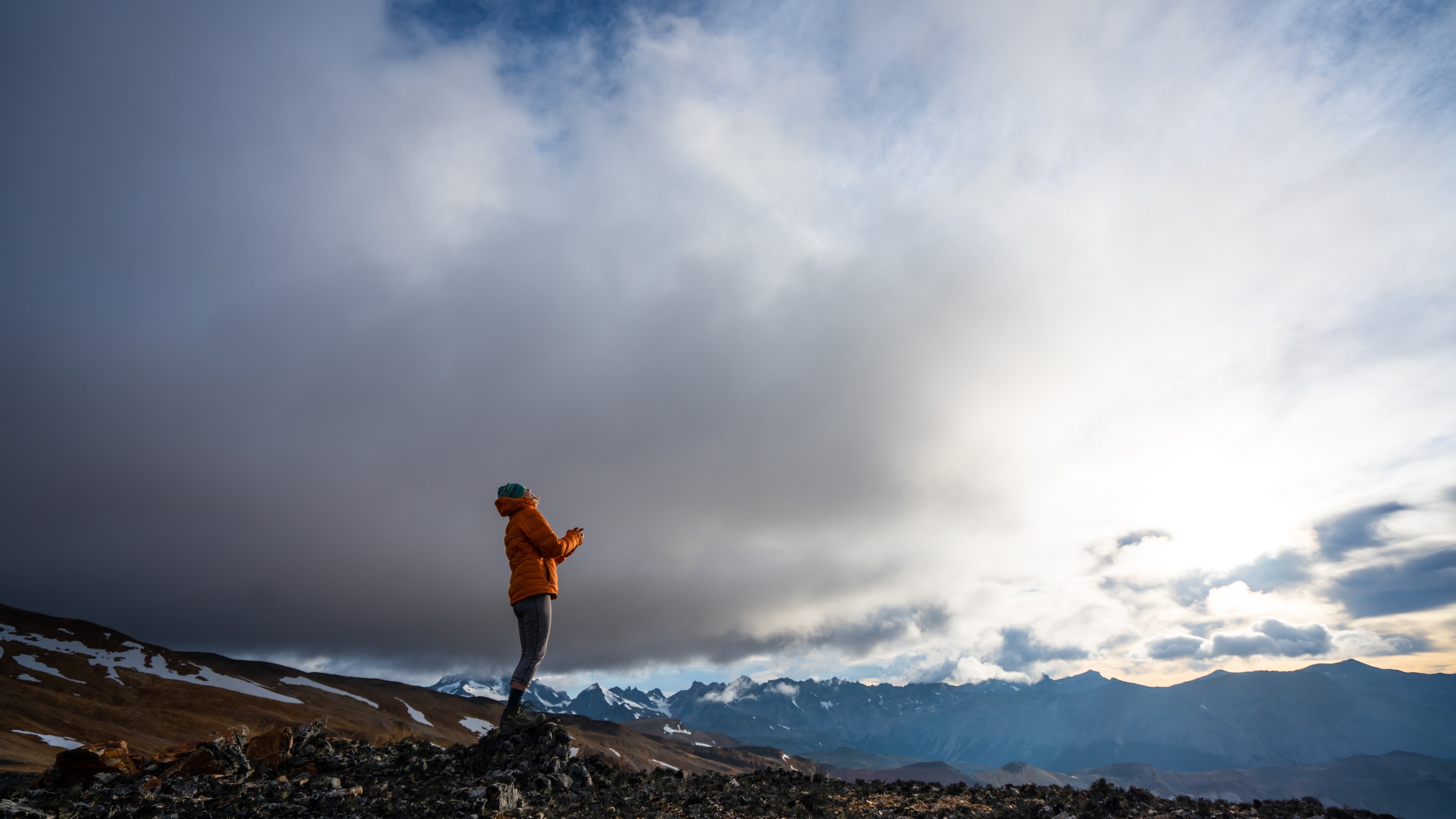 Kris Tompkins looks up at the sky with the Patagonian mountain range as her backdrop. (Jimmy Chin)