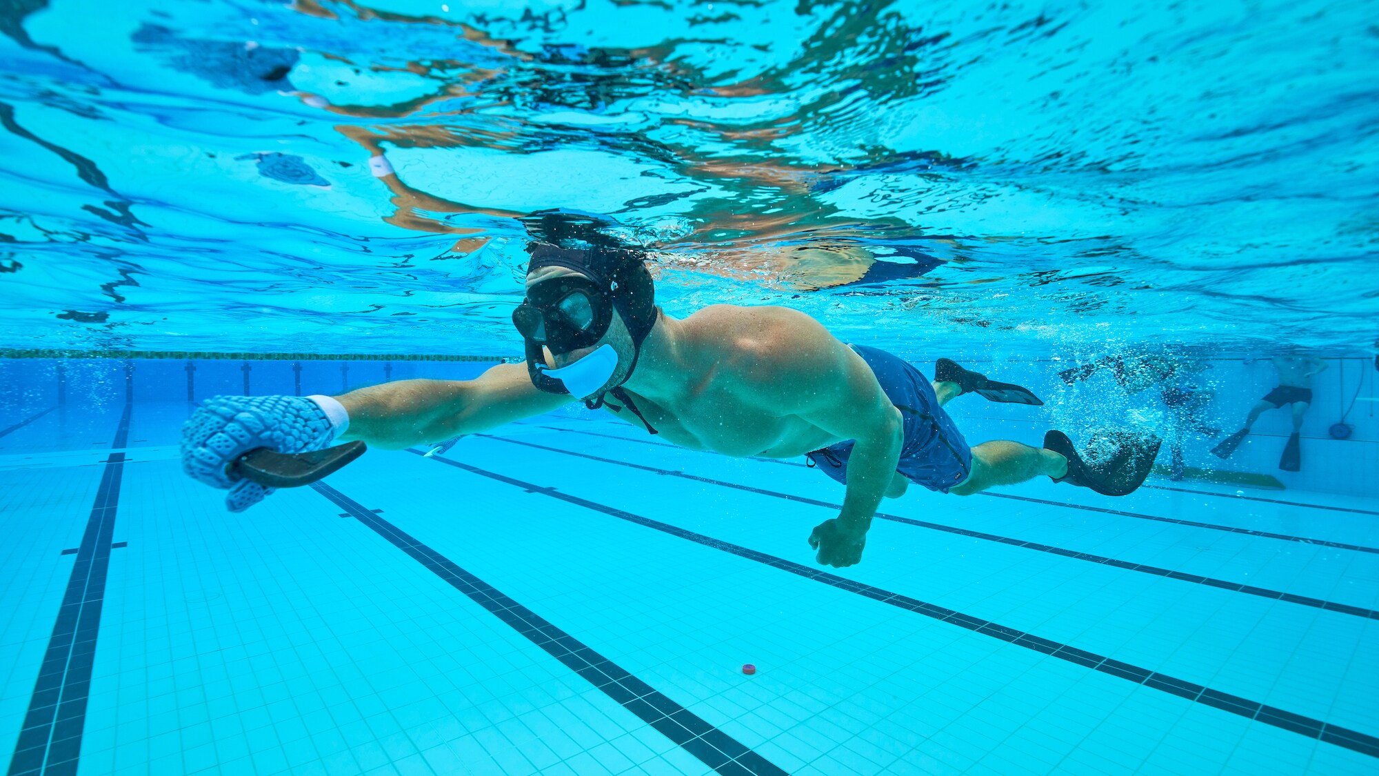 Chris Hemsworth plays underwater hockey. (National Geographic for Disney+/Craig Parry)