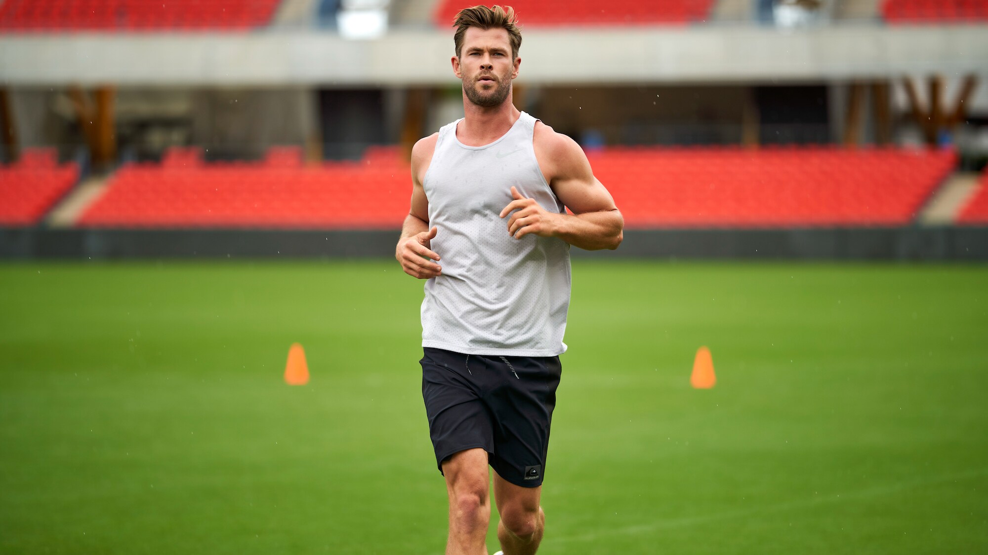 Chris Hemsworth runs on a field. (National Geographic for Disney+/Craig Parry)