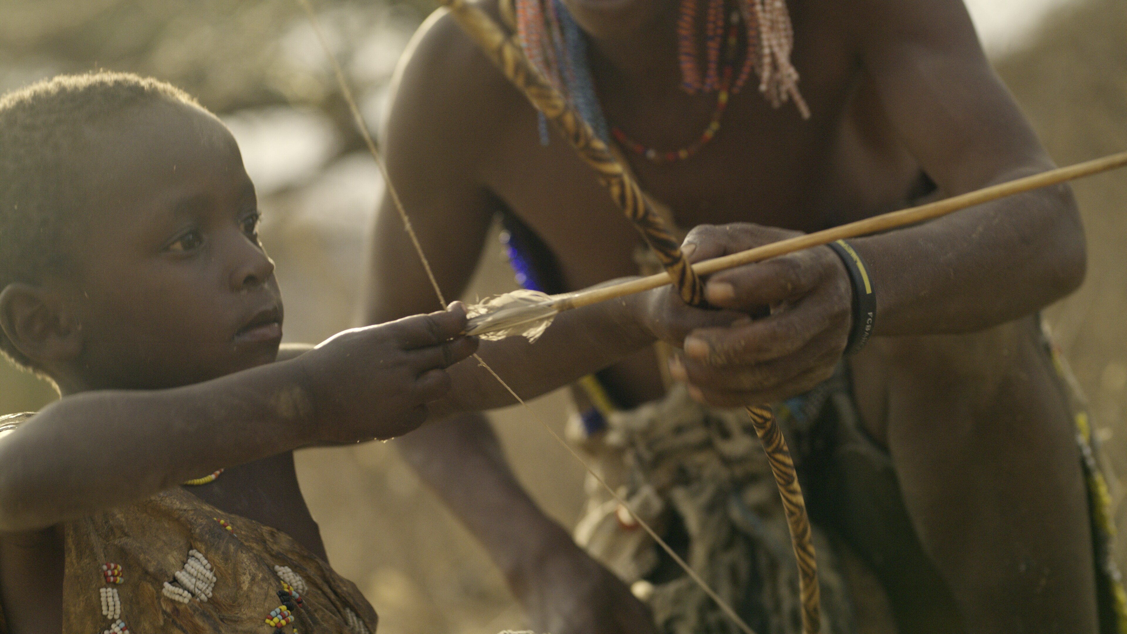 A Hadza tribe child shoots a bow and arrow. (National Geographic for Disney+)
