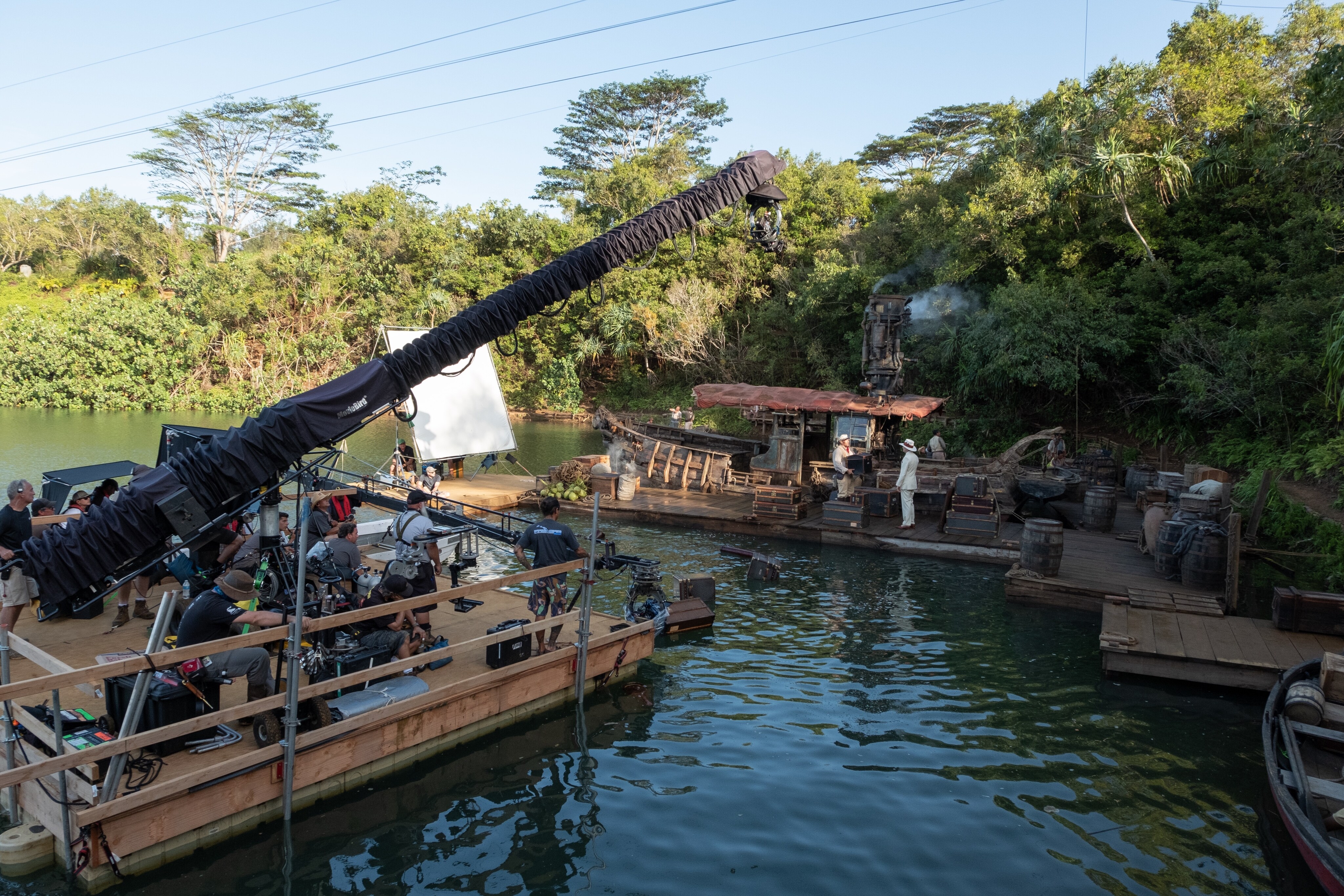 Behind the scenes photo of camera crew on set filming Dwayne Johnson and Jack Whitehall at the docking area surrounded by water.