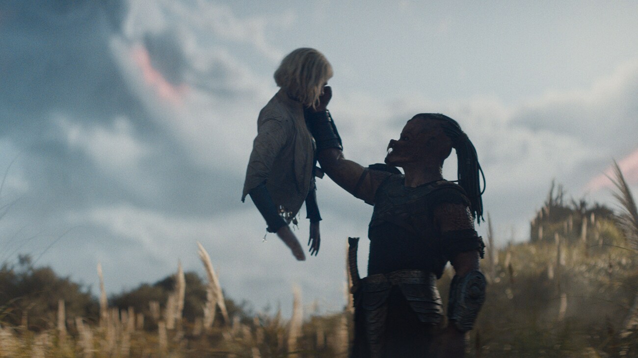 (L-R) Thia (Elle Fanning) and Dek (Dimitrius Schuster-Koloamatangi) in 20th Century Studios' PREDATOR: BADLANDS film. Photo courtesy of 20th Century Studios. © 2025 20th Century Studios. All Rights Reserved.
