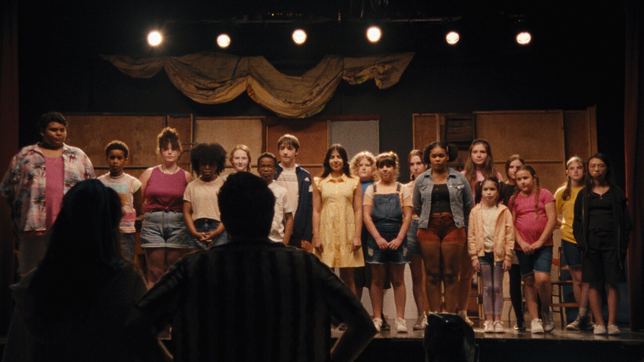 A group of people on a stage from the Searchlight Pictures movie, "Theater Camp."