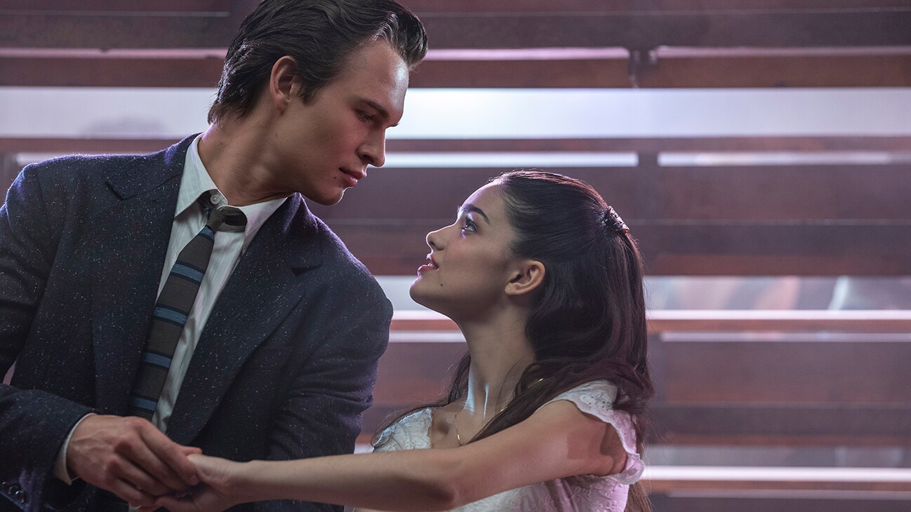 Actors Ansel Elgort and Rachel Zegler stare at each other holding hands form the 20th Century Studios movie "West Side Story."