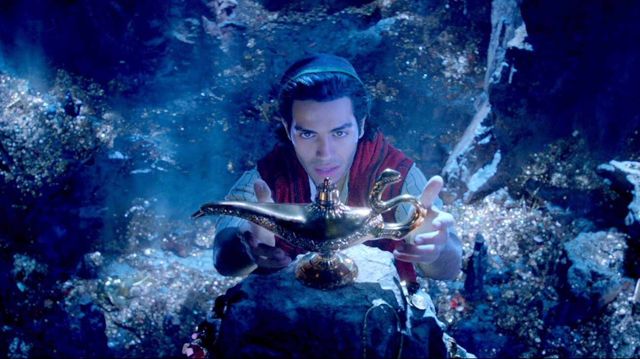 Mena Massoud (as Aladdin) reaching for the magic lamp in Aladdin