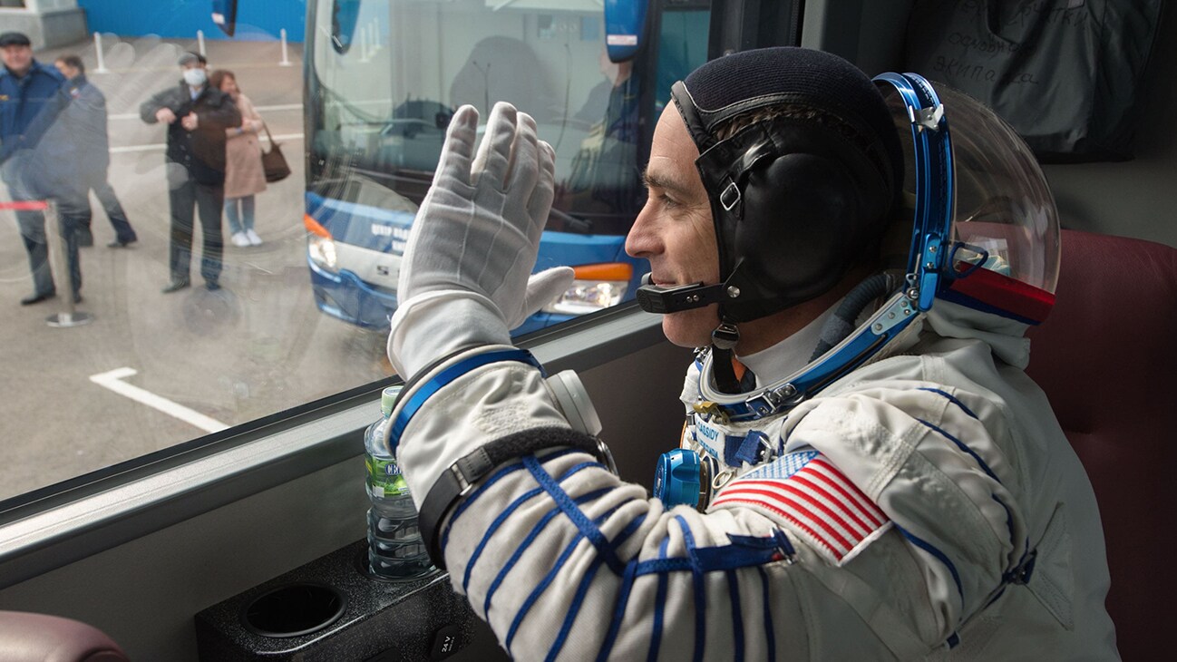 AMONG THE STARS - Expedition 63 crewmember Chris Cassidy of NASA waves farewell as he, Anatoly Ivanishin, and Ivan Vagner of Roscosmos depart building 254 via bus for the launch pad, Thursday, April 9, 2020 at the Baikonur Cosmodrome in Kazakhstan. A few hours later, they lifted off on a Soyuz rocket for a six-and-a-half month mission on the International Space Station. (NASA/GCTC/Andrey Shelepin)  CHRIS CASSIDY