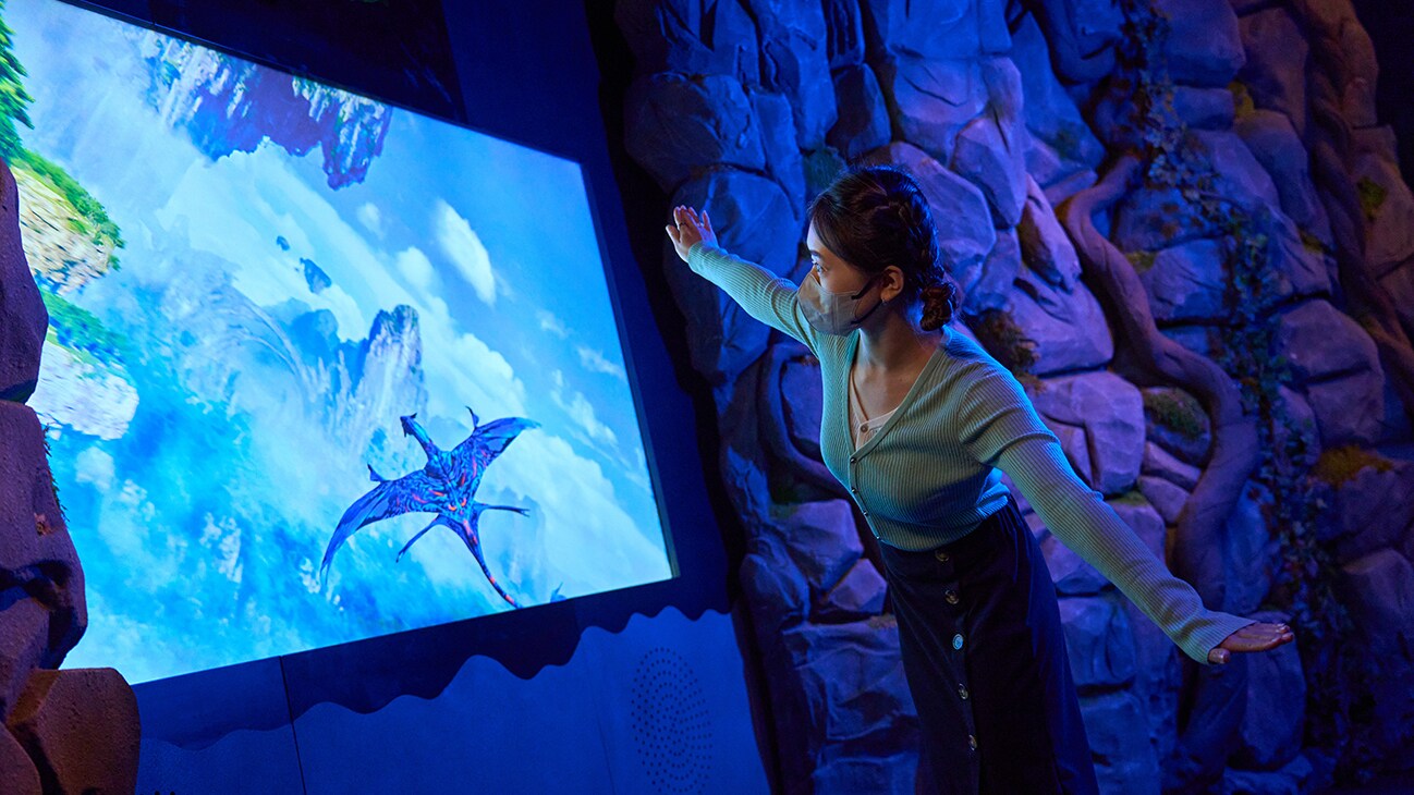 A girl spreads her arms out as she interacts with a digital installation, following the movement of a banshee in air. 