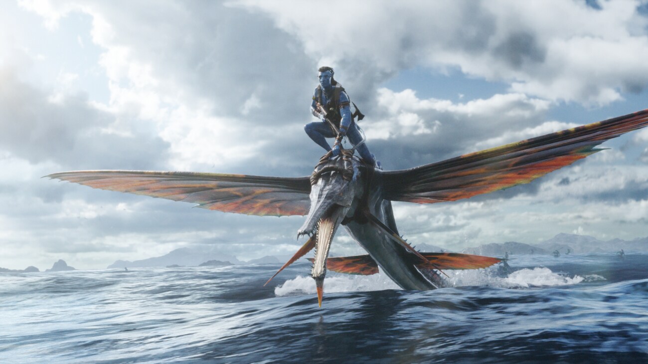 Jake Sully rides a skimwing over the water.