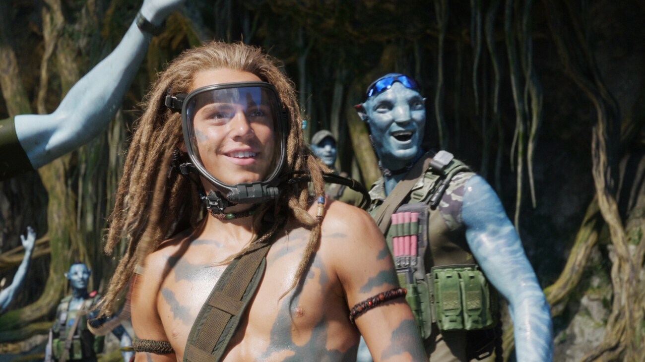 Spider smiles, surrounded by joyful Na'vi in combat gear.