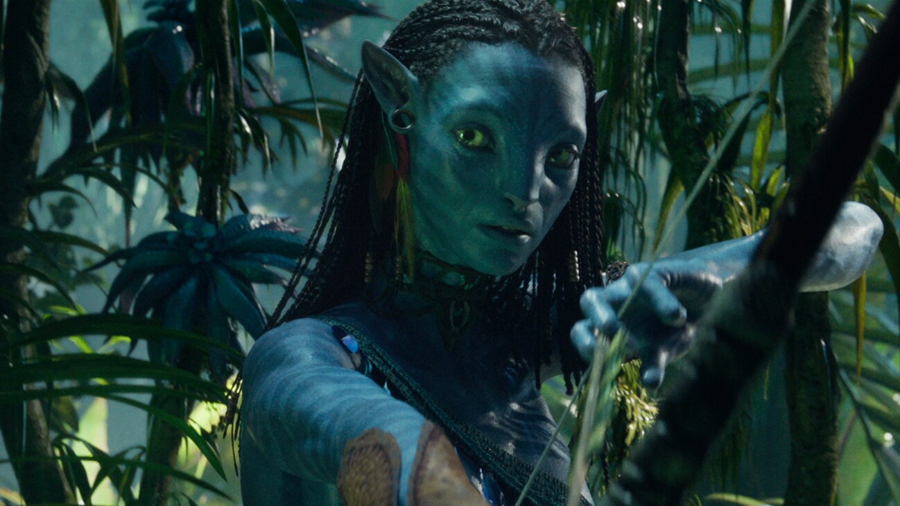 A Na'vi character holding a drawn bow from the 20th Century Studios movie, "Avatar: The Way of Water".