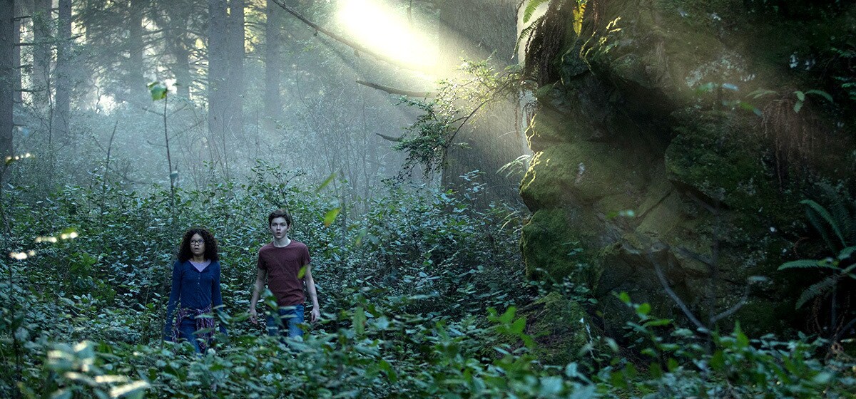 Meg Murry (played by Storm Reid) and Calvin (played by Levi Miller) in the forest in A Wrinkle in Time