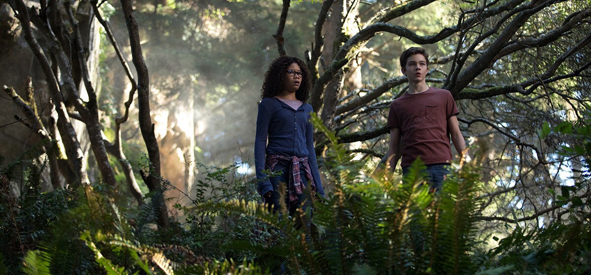 Meg Murry (played by Storm Reid) and Calvin (played by Levi Miller) in the forest in A Wrinkle in Time