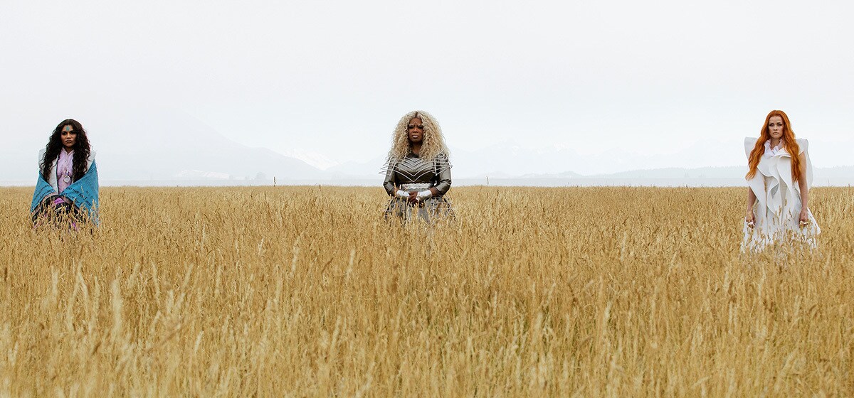 Mrs. Who (played by Mindy Kaling), Mrs. Which (played by Oprah Winfrey) and Mrs. Whatsit (played by Reese Witherspoon) standing in a field of wheat in the movie "A Wrinkle in Time"