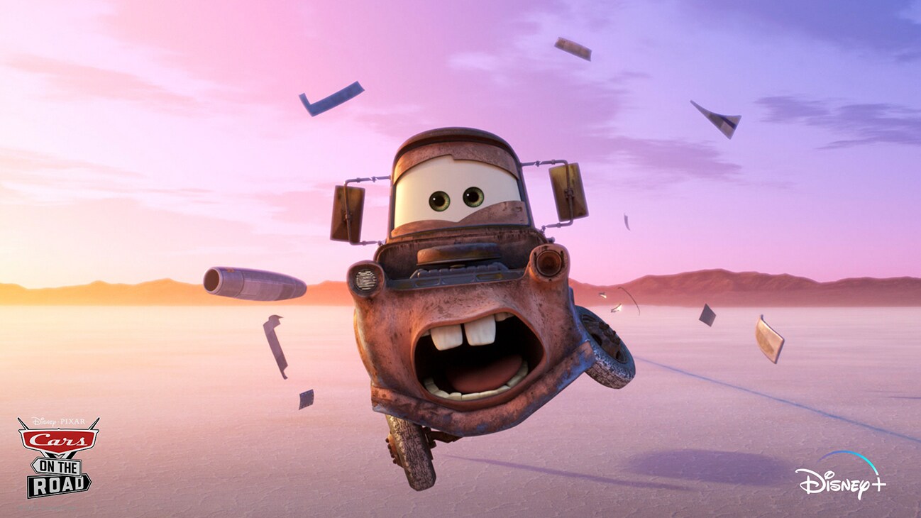 Mater (voice of Larry the Cable Guy) jumping on a salt flat from the Disney+ Original series "Cars on the Road".