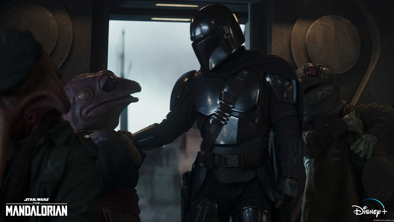 (Center, l-r): Frog Lady and the Mandalorian (Pedro Pascal) in Lucasfilm's THE MANDALORIAN, season two, exclusively on Disney+. © 2020 Lucasfilm Ltd. & ™. All Rights Reserved..