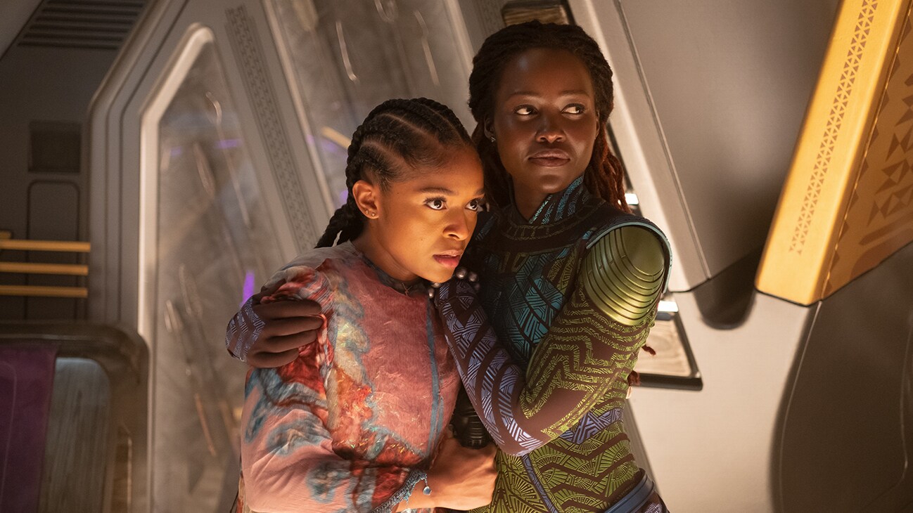 Nakia (actor Lupita Nyong'o) holds Riri Williams (actor Dominique Thorne) close in a protective embrace. From the film, Marvel Studios' Black Panther: Wakanda Forever.