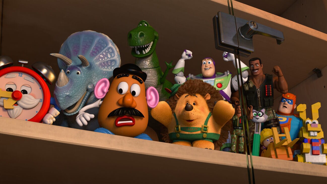 (L - R) Old Timer, Trixie (Kristen Schaal), Mr. Potato Head (Don Rickles), Rex (Wallace Shawn), Mr. Pricklepants (Timothy Dalton), Buzz Lightyear (Tim Allen), Combat Carl (Carl Weathers), and others sitting on the shelf of a glass cabinet in Toy Story of Terror! (2013).