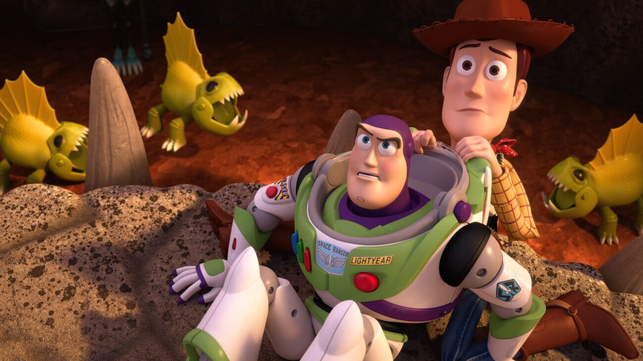 Buzz Lightyear (Tim Allen) and Sheriff Woody (Tom Hanks) looking up at Reptillus Maximus after being knocked to the floor at the edge of the gladiator arena in Toy Story That Time Forgot (2014).