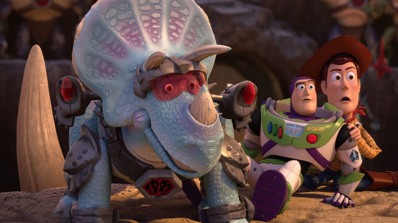 An armored Trixie (Kristen Schaal) defends Buzz Lightyear (Tim Allen), and Sheriff Woody (Tom Hanks) from the Battlesaurs in Toy Story That Time Forgot (2014).