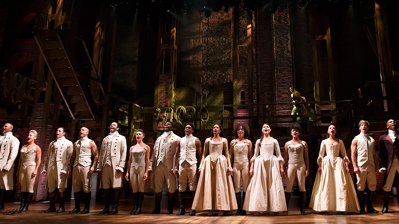 Image of the cast of Hamilton on stage singing from the Disney+ Original movie "Hamilton".