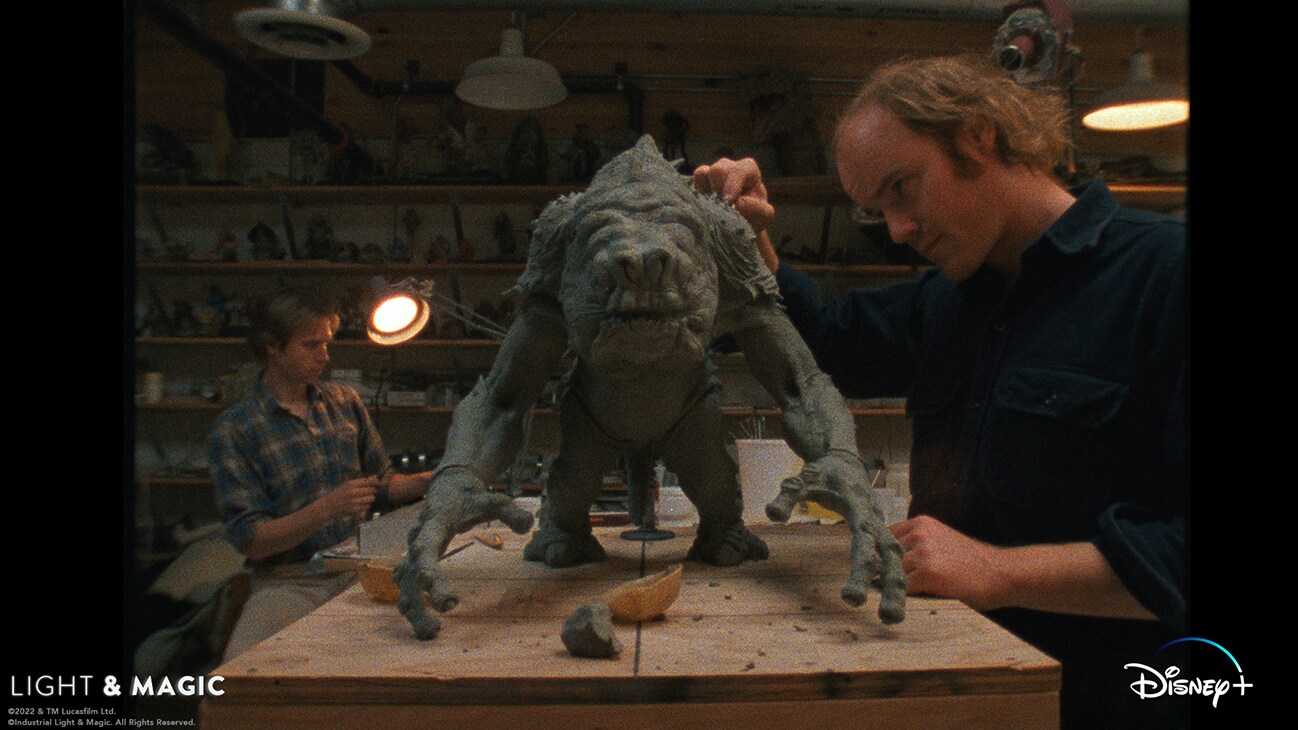 ILM artist inspecting a clay model of the Rancor creature from the Disney+ Original series, "Light & Magic". | © & ™ Lucasfilm Ltd. ©Industrial Light & Magic. All Rights Reserved.