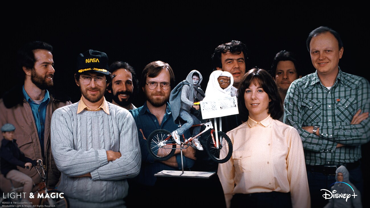 Steven Spielberg, Kathleen Kennedy, and ILM artists in front of a model of Elliott and E.T. on a bike from the Disney+ Original series, "Light & Magic". | © & ™ Lucasfilm Ltd. ©Industrial Light & Magic. All Rights Reserved.
