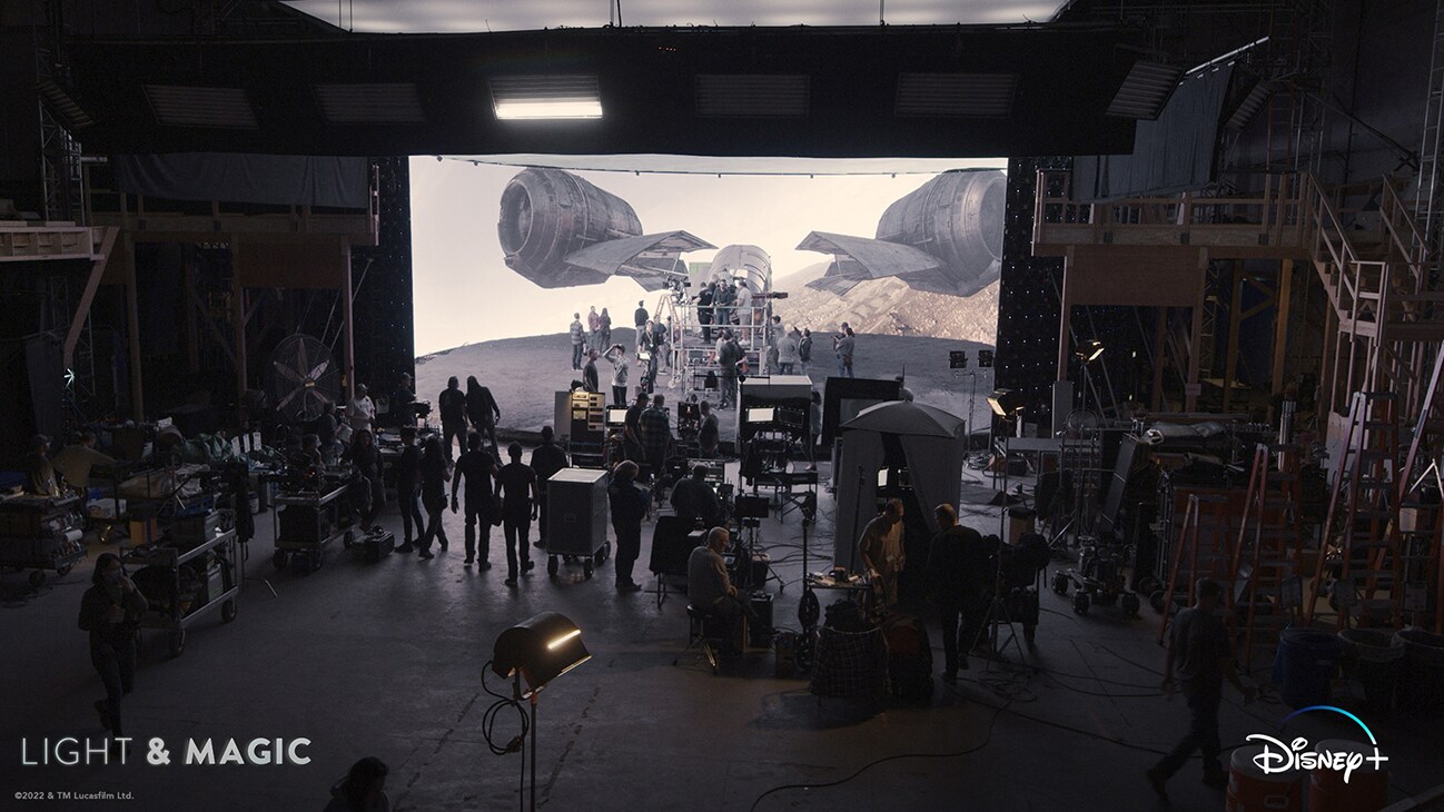 Image of the Razor Crest ship from The Mandalorian on a movie screen in front of a group of people working with equipment. From the Disney+ Original series "Light & Magic". | © & ™ Lucasfilm Ltd. ©Industrial Light & Magic. All Rights Reserved.