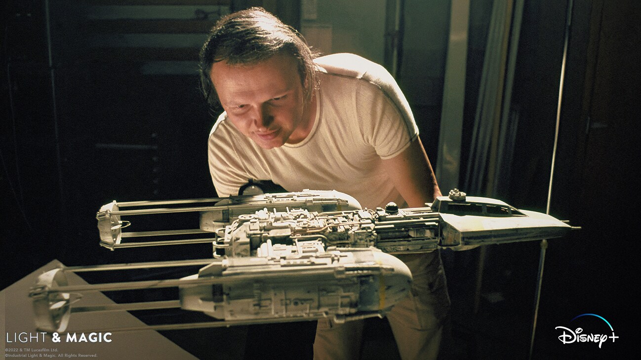 Image of a person working on a Y-wing fighter model from the Disney+ Original series, "Light & Magic". | © & ™ Lucasfilm Ltd. ©Industrial Light & Magic. All Rights Reserved.