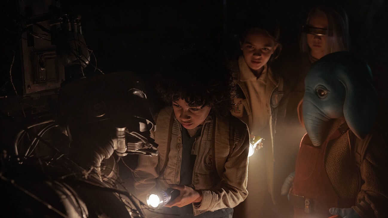 (L-R): SM-33 (voiced by Nick Frost), Wim (Ravi Cabot-Conyers), Fern (Ryan Kiera Armstrong), KB (Kyriana Kratter), and Neel (Robert Timothy Smith) in Lucasfilm's STAR WARS: SKELETON CREW, exclusively on Disney+. Photo by Matt Kennedy. ©2024 Lucasfilm Ltd. & TM. All Rights Reserved.