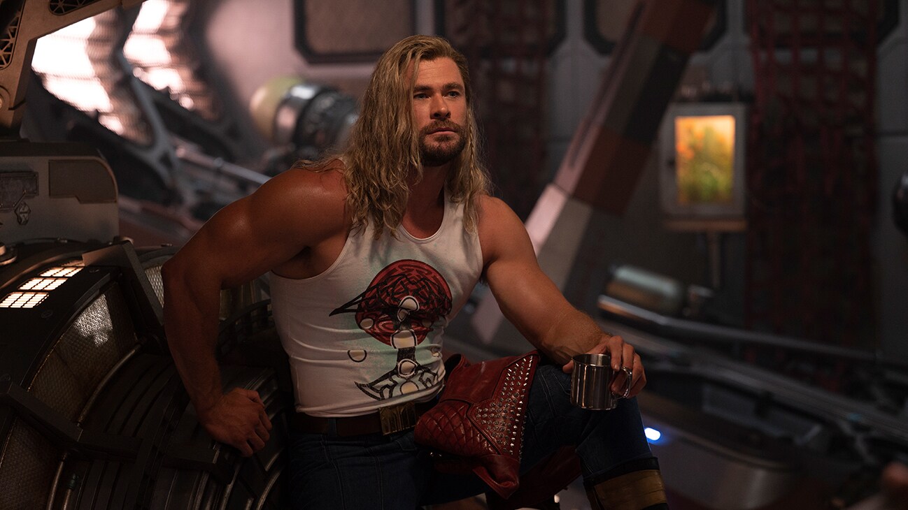 Thor (actor Chris Hemsworth) sits in a ship, enjoying a drink in Marvel Studios' Thor: Love and Thunder.