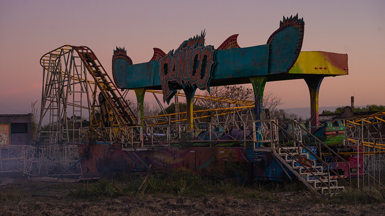An old, worn-down rollercoaster in an overgrown field, from the Disney+ Original series, Tierra Incognita. 