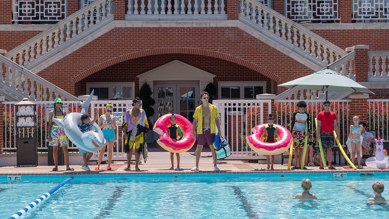 The cast of the Disney+ Original movie "Cheaper by the Dozen" looking pool-ready in front of their community pool.