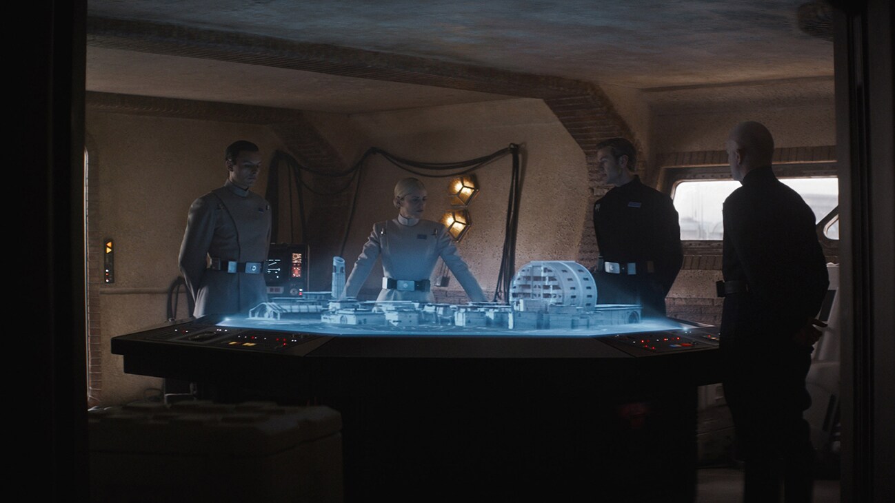 Imperial officers standing around a holograph table from the Disney+ Original series, "Andor."