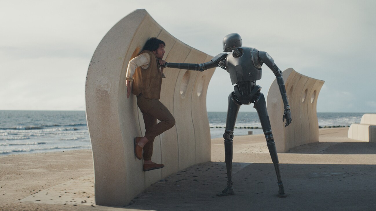 Cassian Andor (actor Diego Luna) being held by the throat against a wall by an Imperial droid from the Disney+ Original series, "Andor."