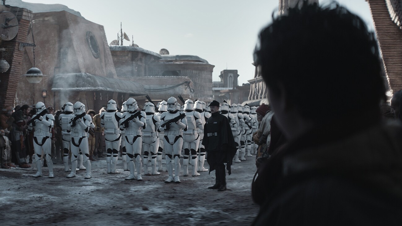 An Imperial officer and troops standing in a street from the Disney+ Original series, "Andor."