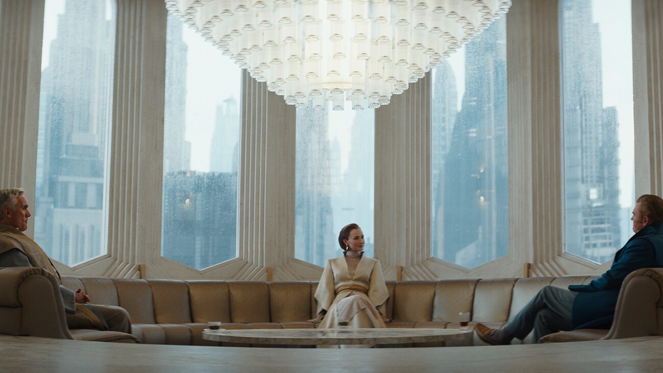 Mon Mothma (actor Genevieve O'Reilly) sitting on a sofa in a room with large windows from the Disney+ Original series, "Andor."