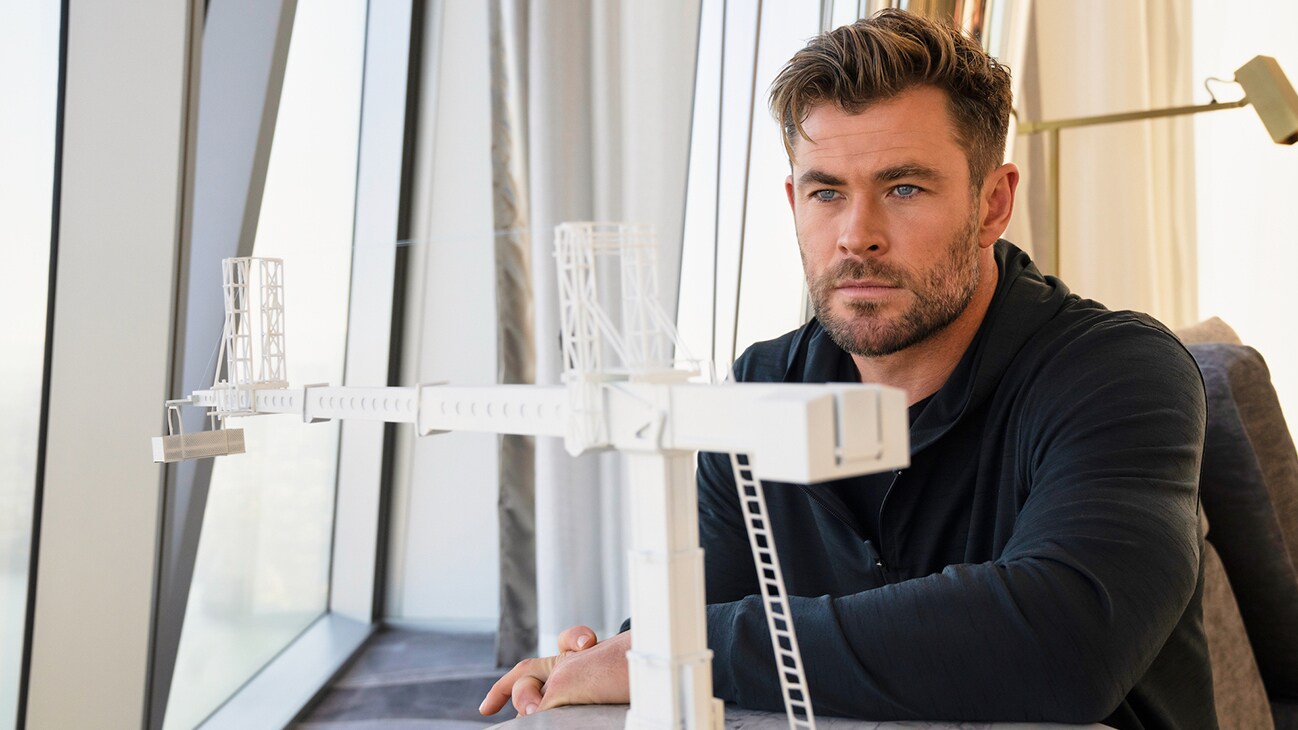 Chris Hemsworth looks at a model of the crane he is about to walk across. (National Geographic for Disney+/Craig Parry)
